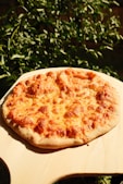 September 5, Cheese Pizza Day,  Photo of cheesy pizza on a wooden board 