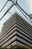 Building's angular architecture framed by power lines.
