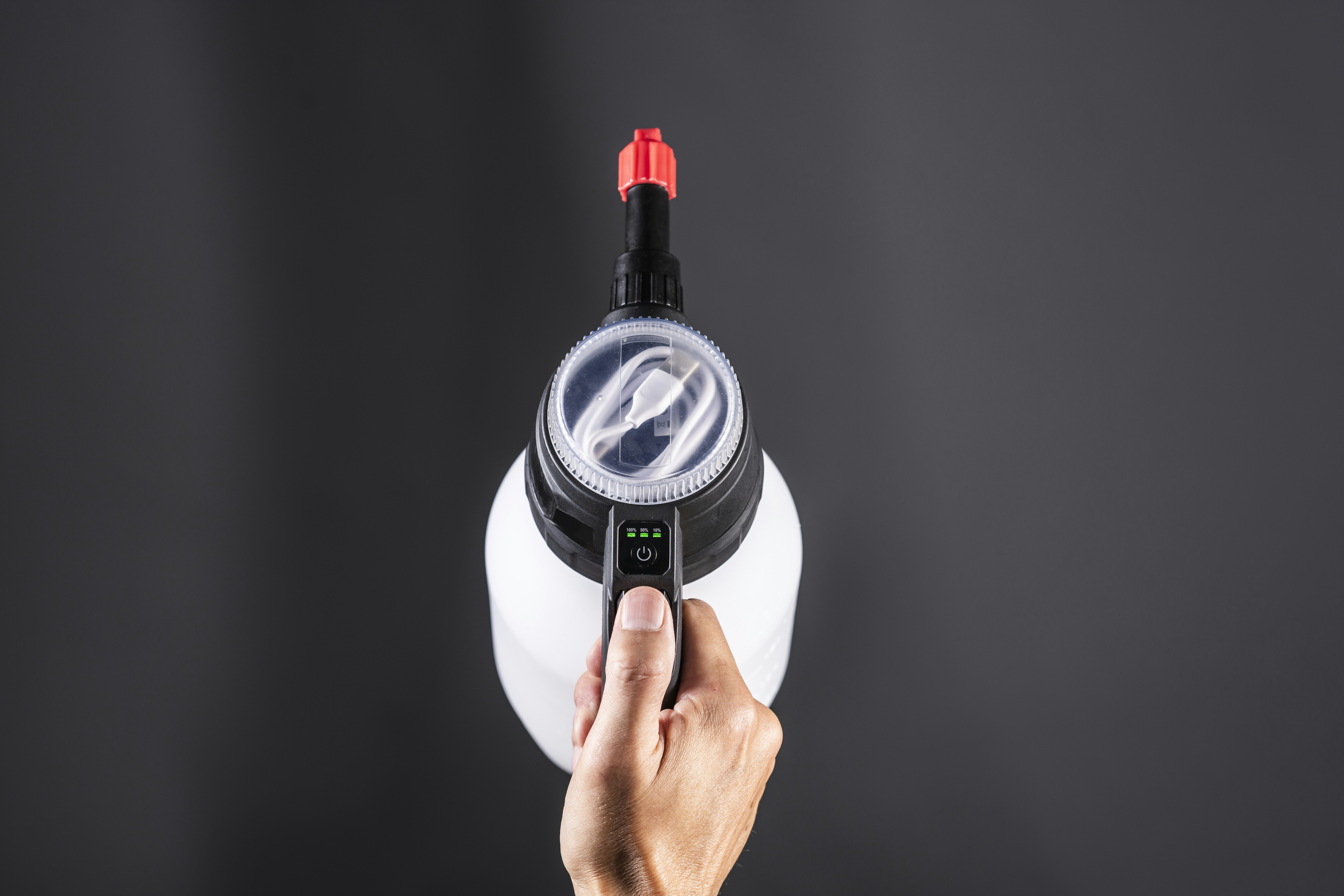 Person holds a white spray bottle overhead.