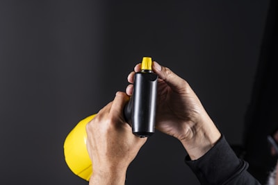Person's hands holding a spray bottle.