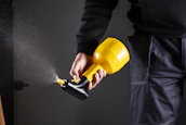 A person is holding a spray gun.