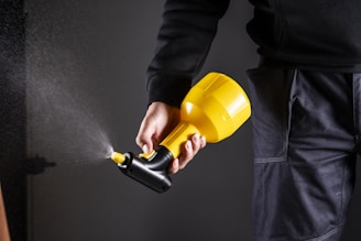 A person is holding a spray gun.
