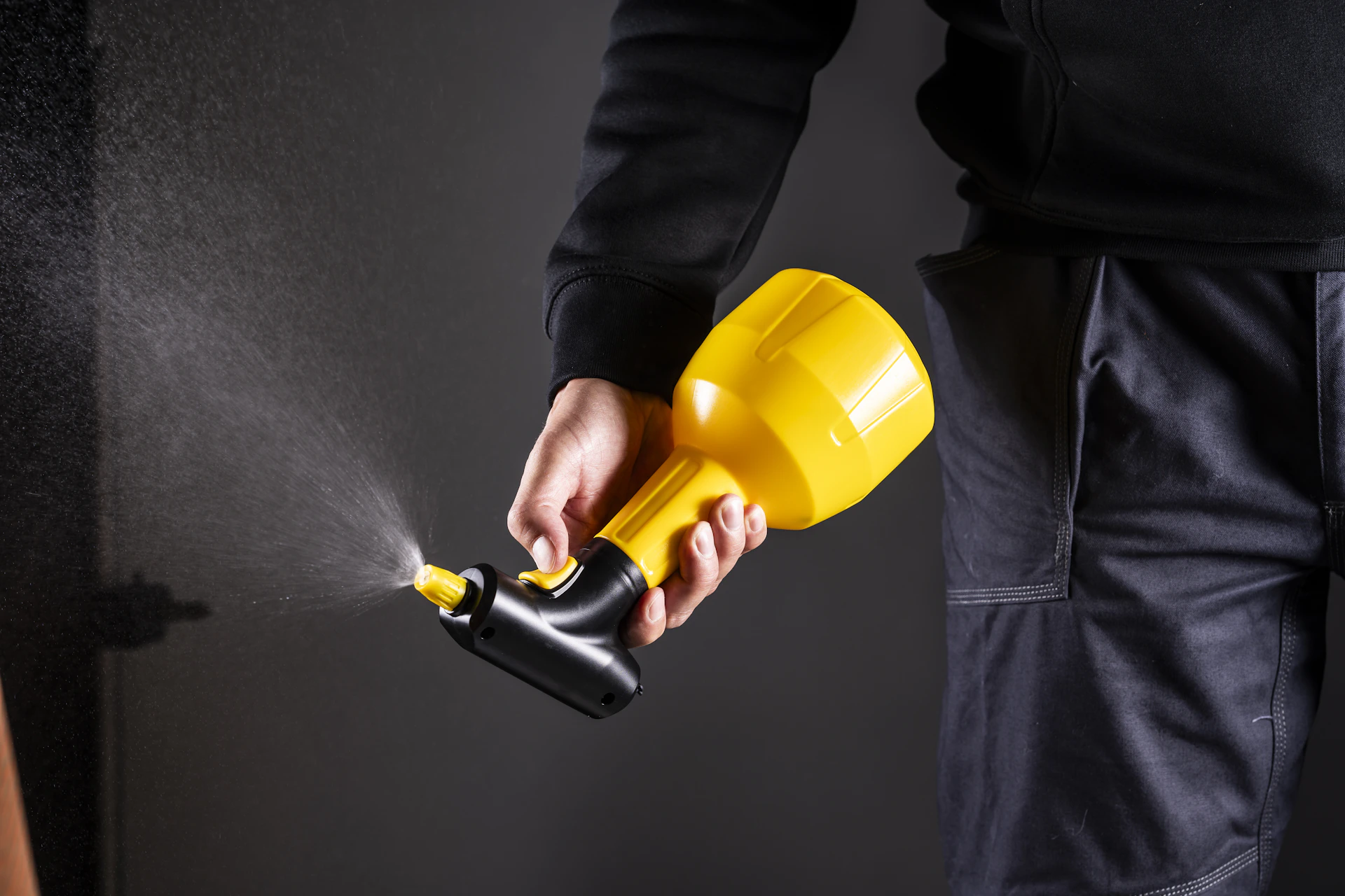 A person is holding a spray gun.