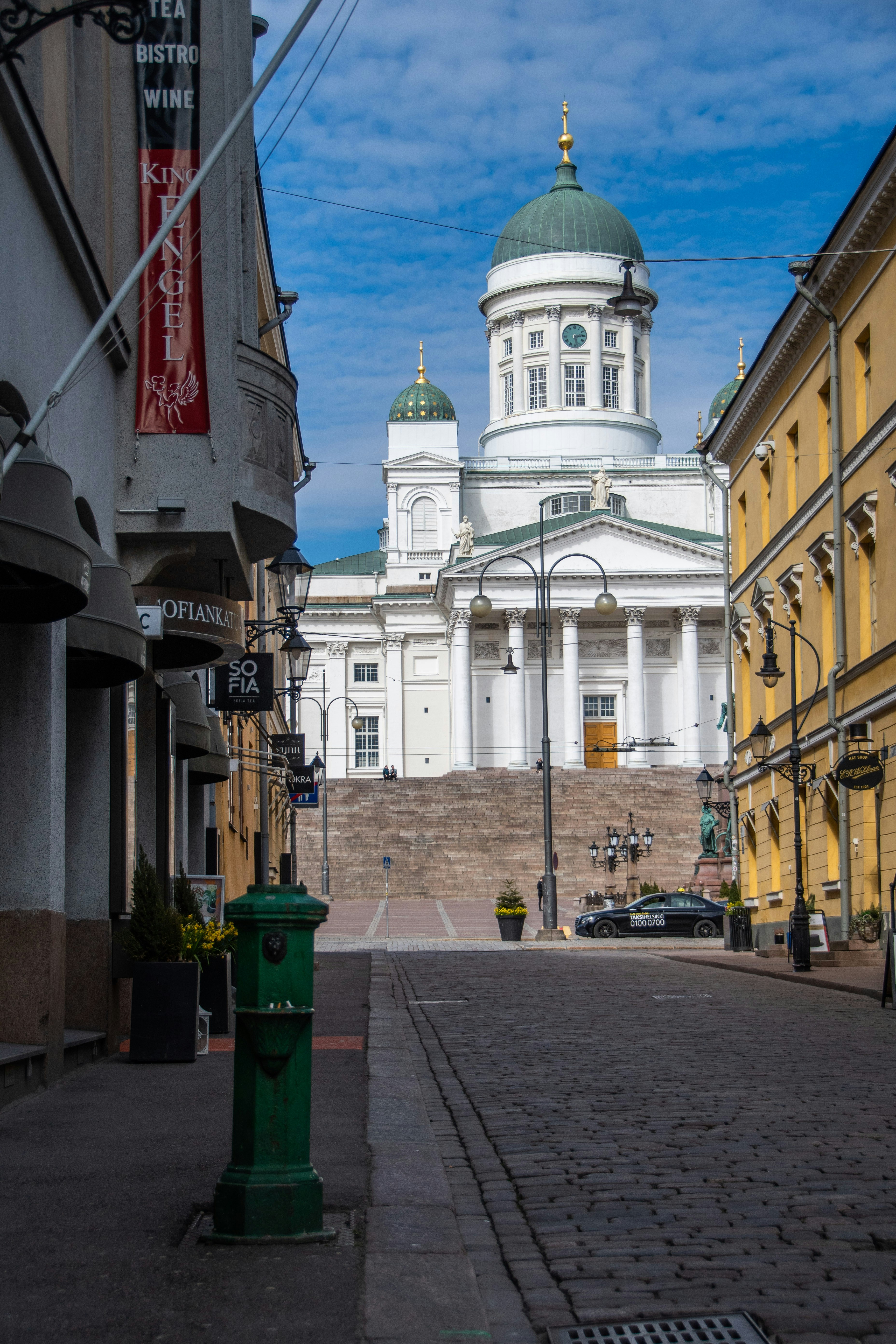 Helsinki cathedral is seen from a cobblestone street.