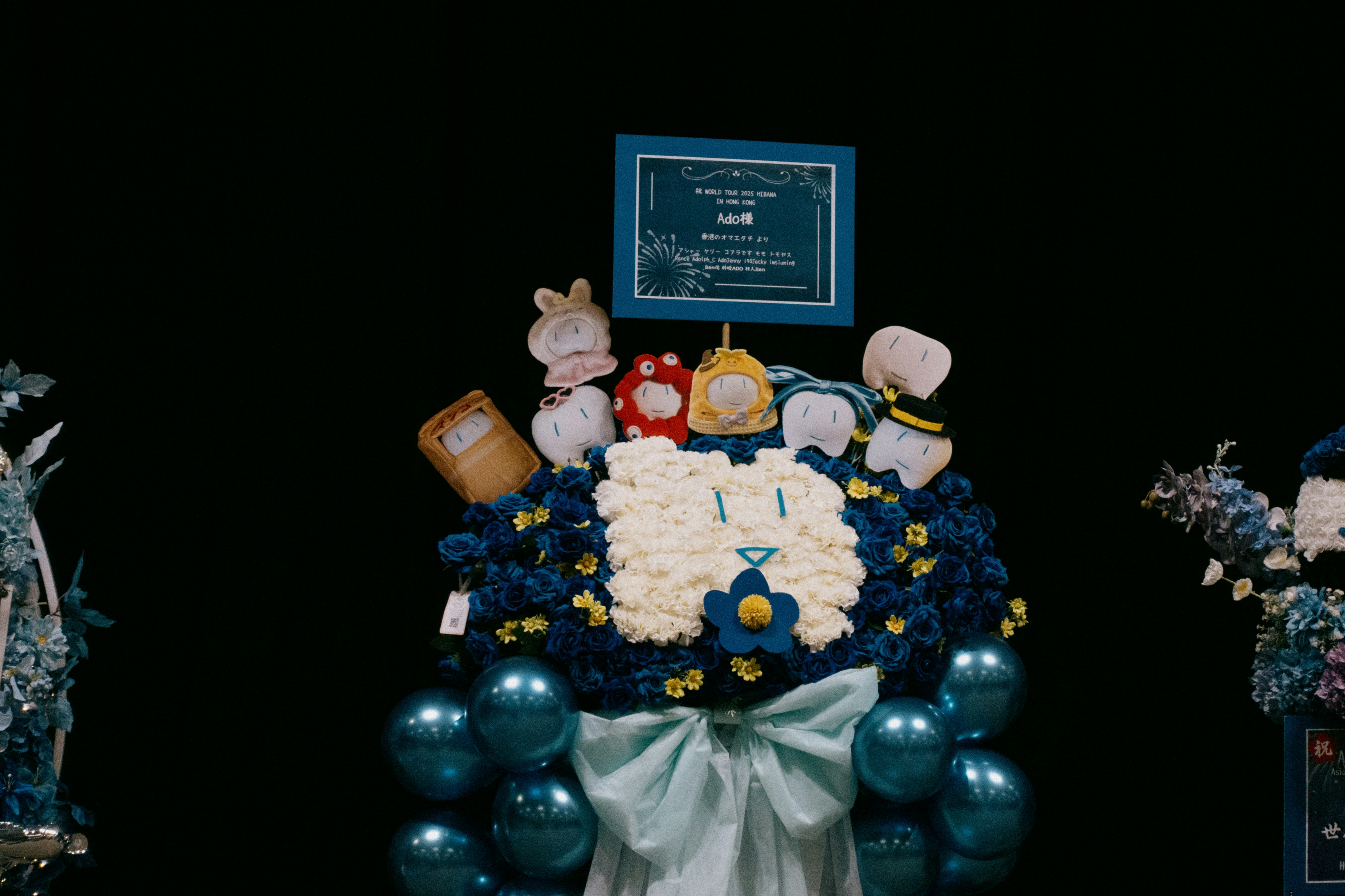 A flower arrangement includes disney characters and a bow.