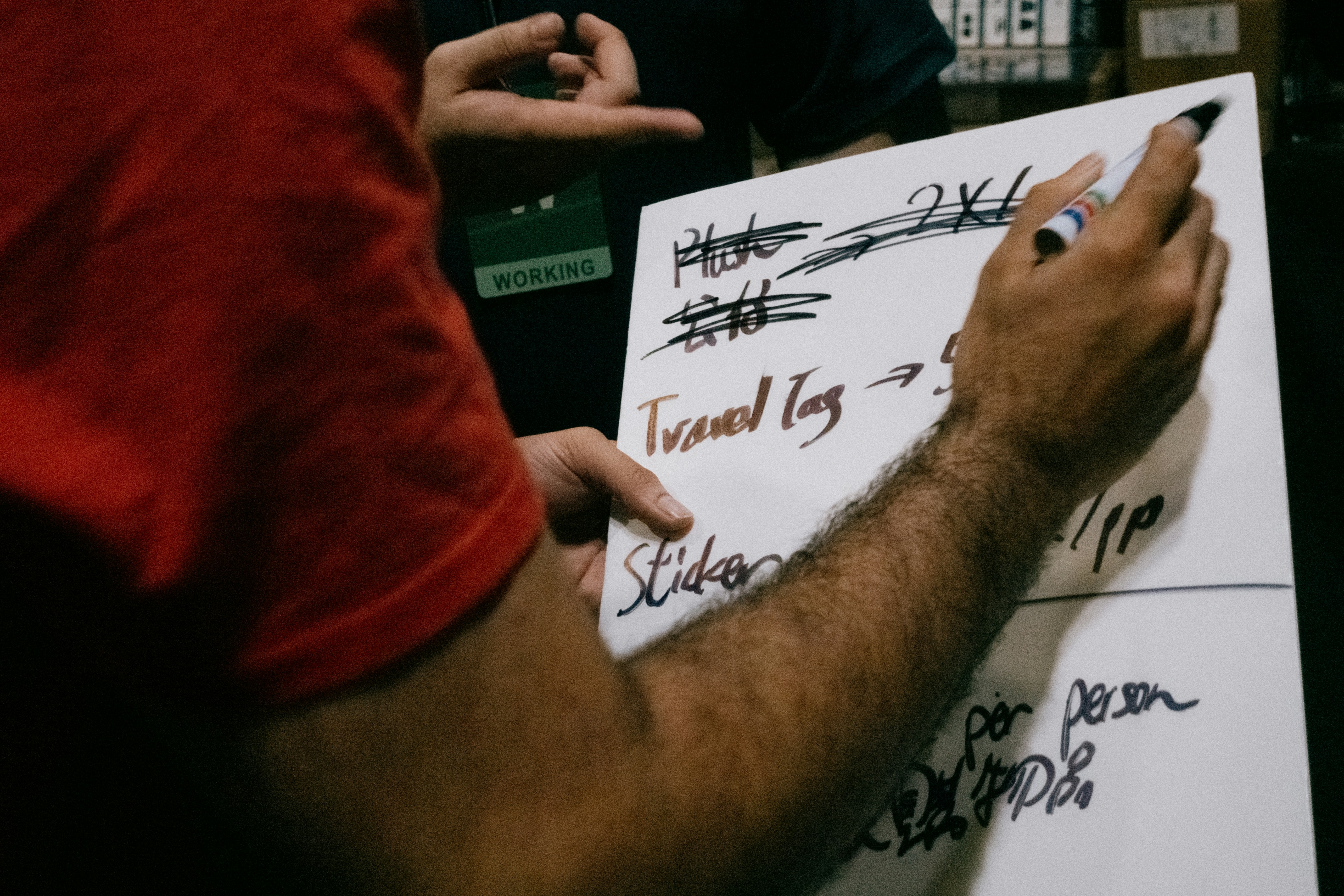 Someone is writing notes on a whiteboard.