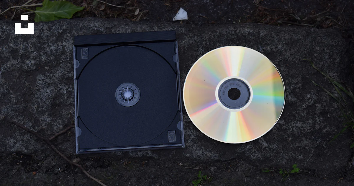 CDとそのケースは石の表面にあります。の写真 – UnsplashのDVDの無料画像