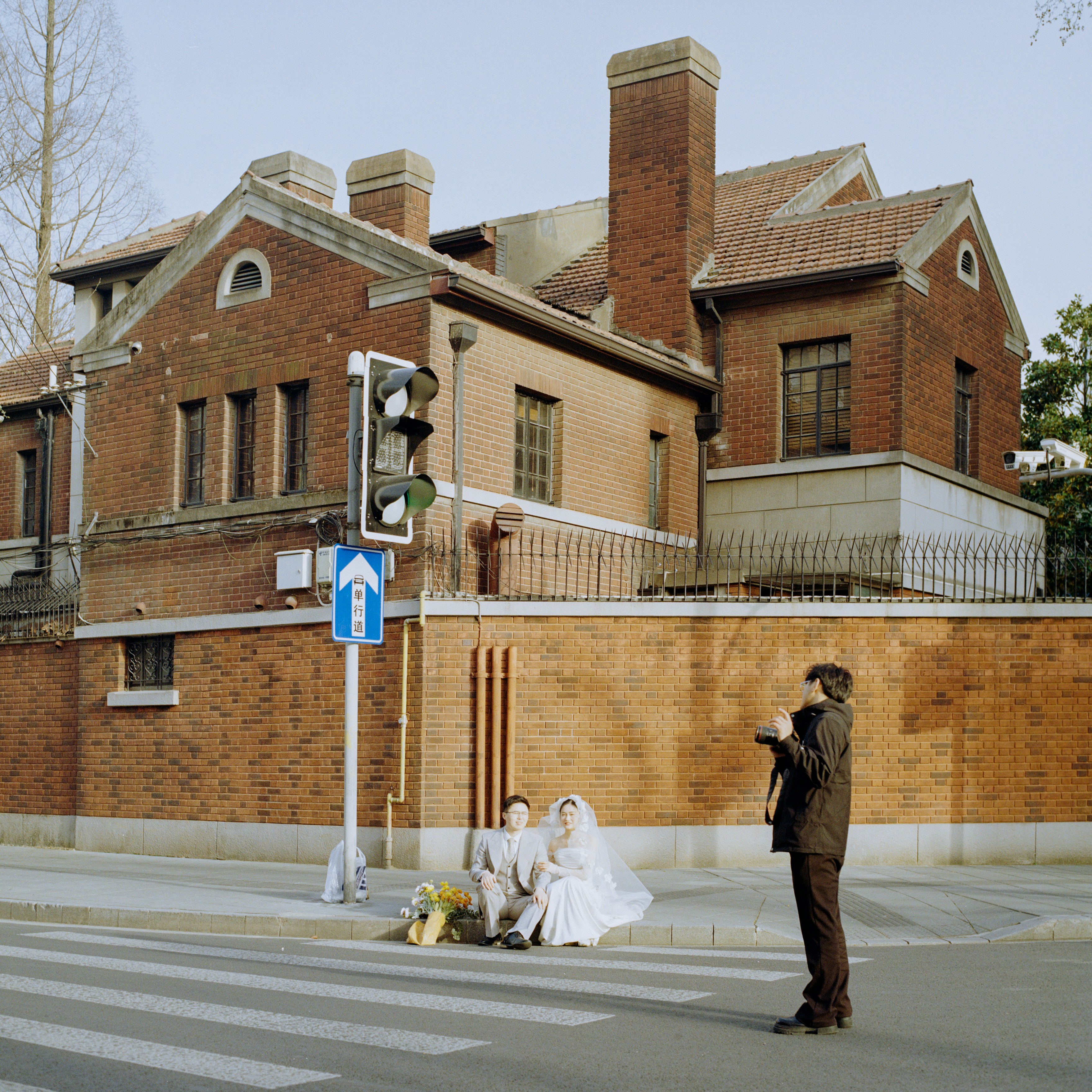 A photographer captures a wedding in front of a house