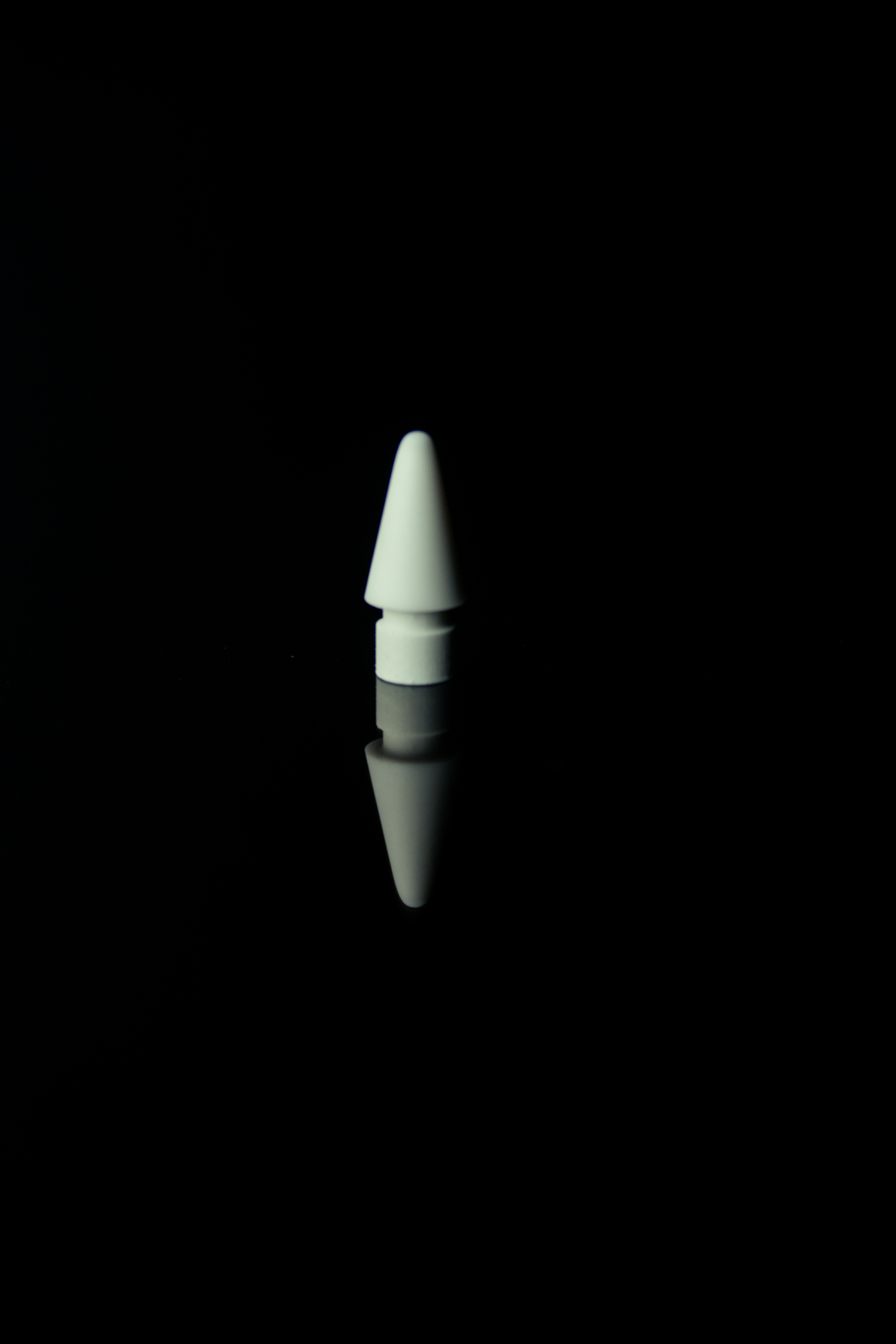 Ujung stylus putih memantulkan permukaan hitam.