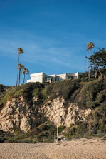 Modern house sits atop a coastal cliff.