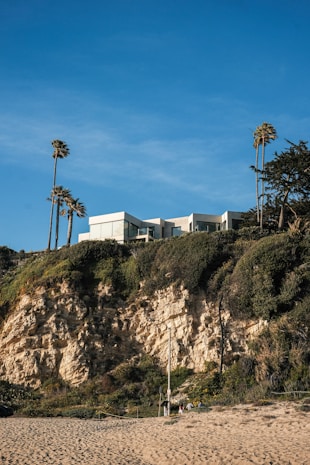 Modern house sits atop a coastal cliff.