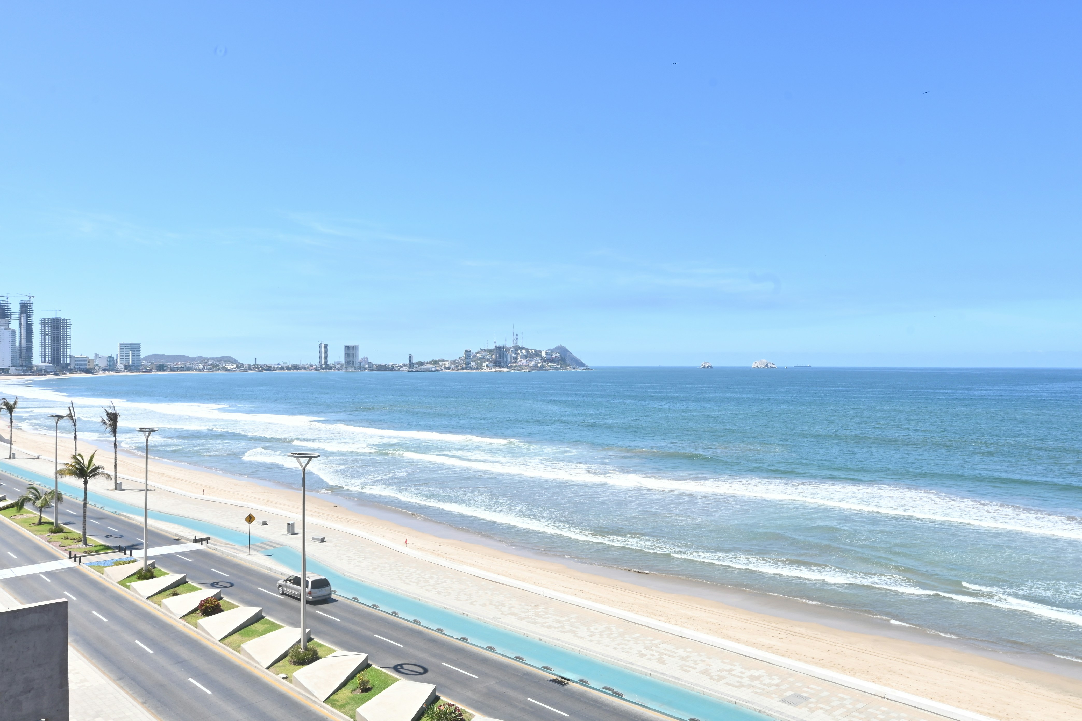 A beautiful beach and ocean under a blue sky.
