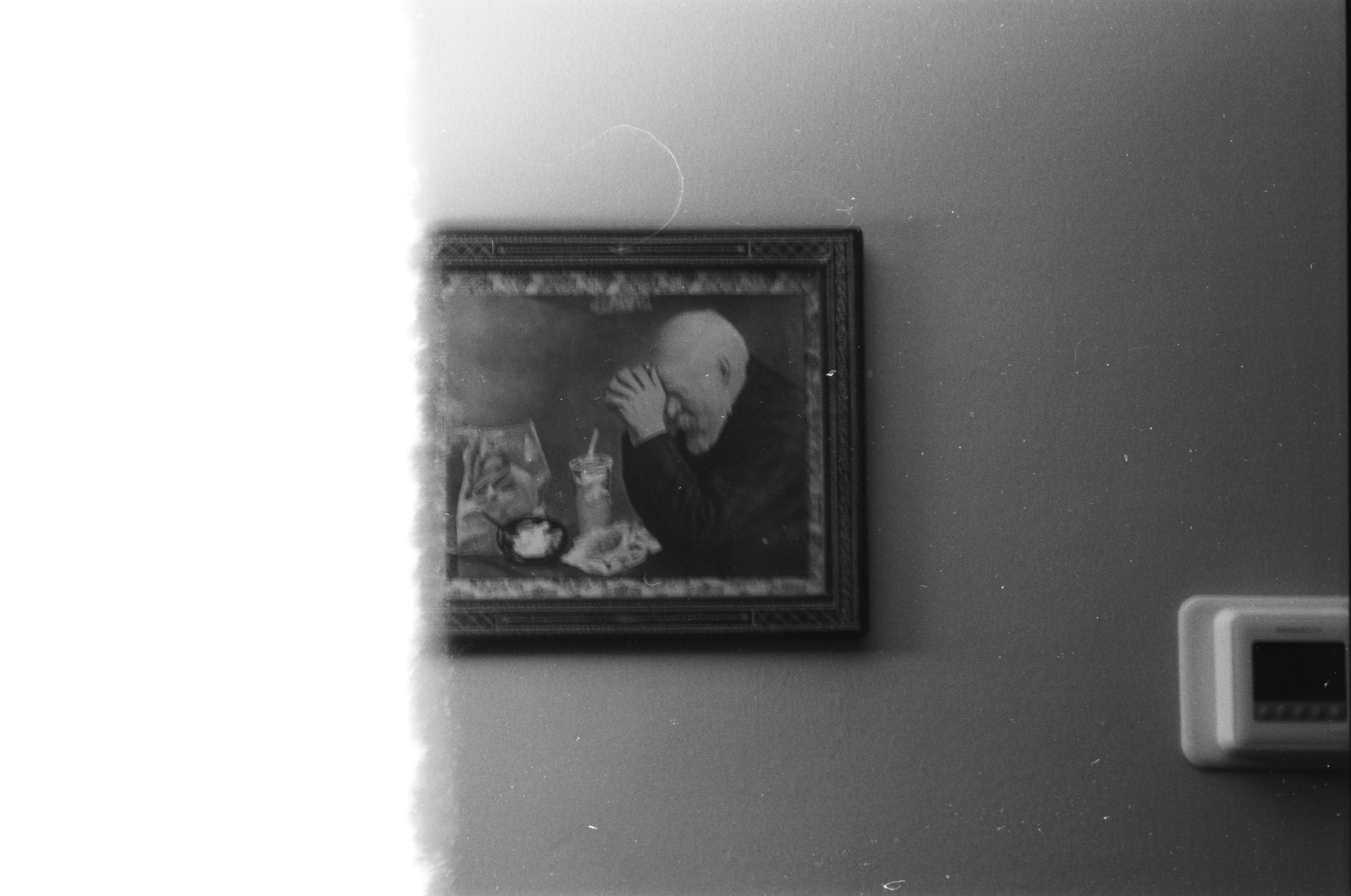 A framed portrait hangs on a wall.
