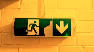 Emergency exit sign is illuminated on a wall.