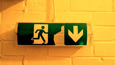 Emergency exit sign is illuminated on a wall.