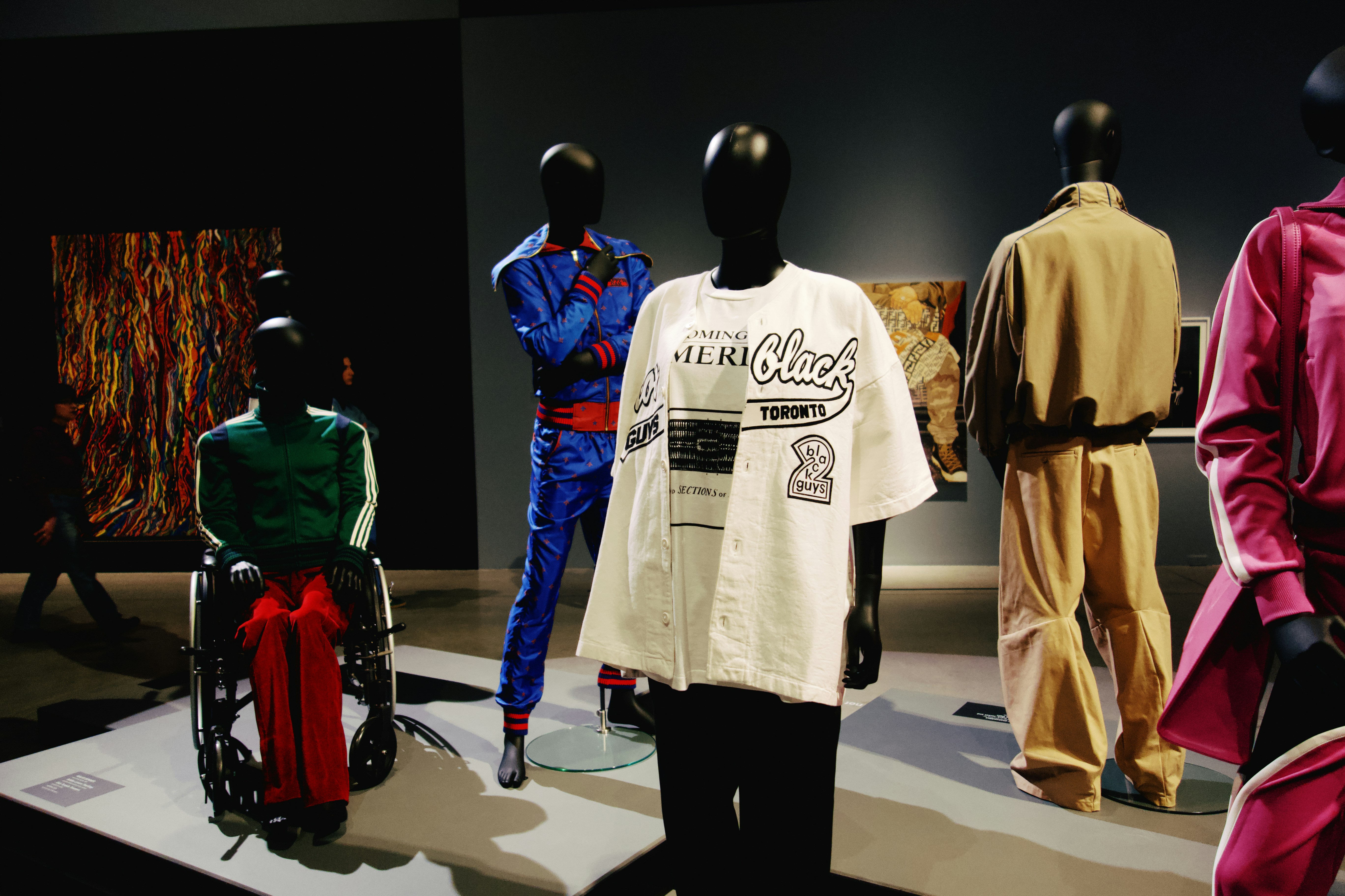 Fashion mannequins are displayed in an art gallery.