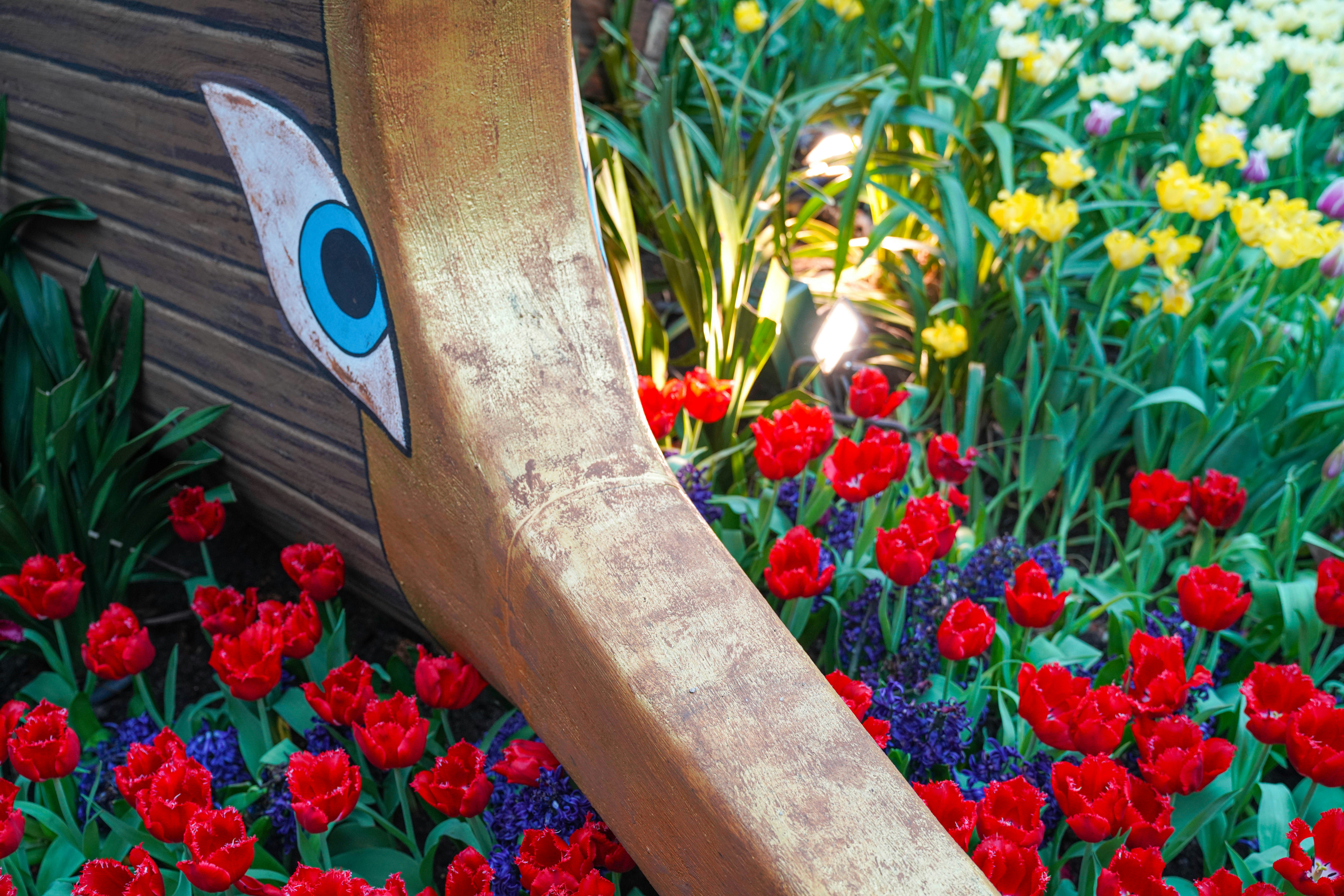 A sculpture with flowers blooming around its base.