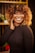 A woman smiles joyfully with beautiful curly hair.