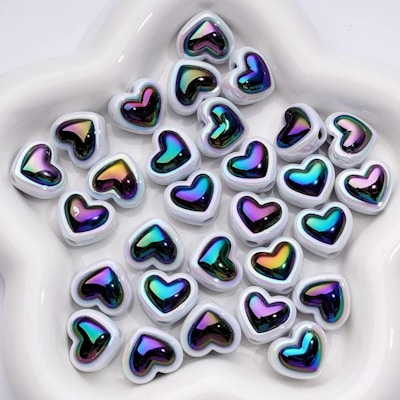 Many colorful heart-shaped beads rest inside of a bowl.