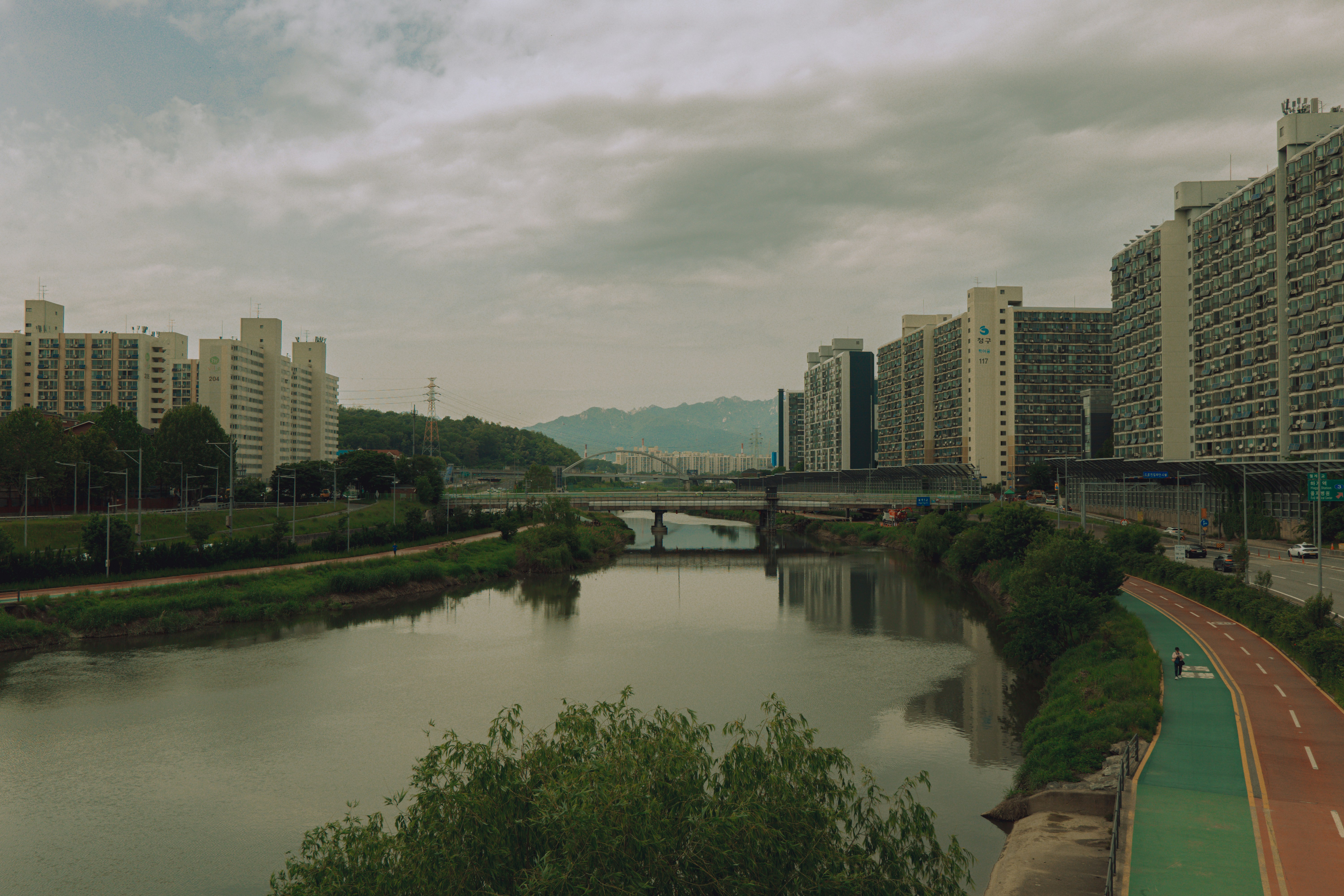 Los edificios bordean un río tranquilo bajo cielos nublados.