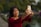 Woman smiling, taking a selfie with her phone.