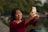 Woman smiling, taking a selfie with her phone.