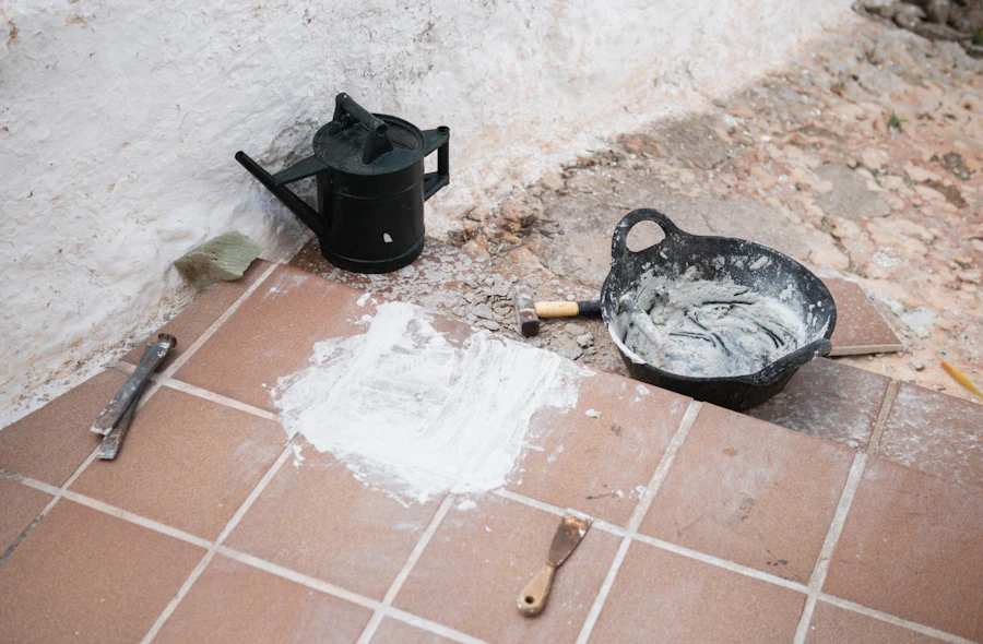Grout, a float and tiling tools laid out on a terracotta tile floor