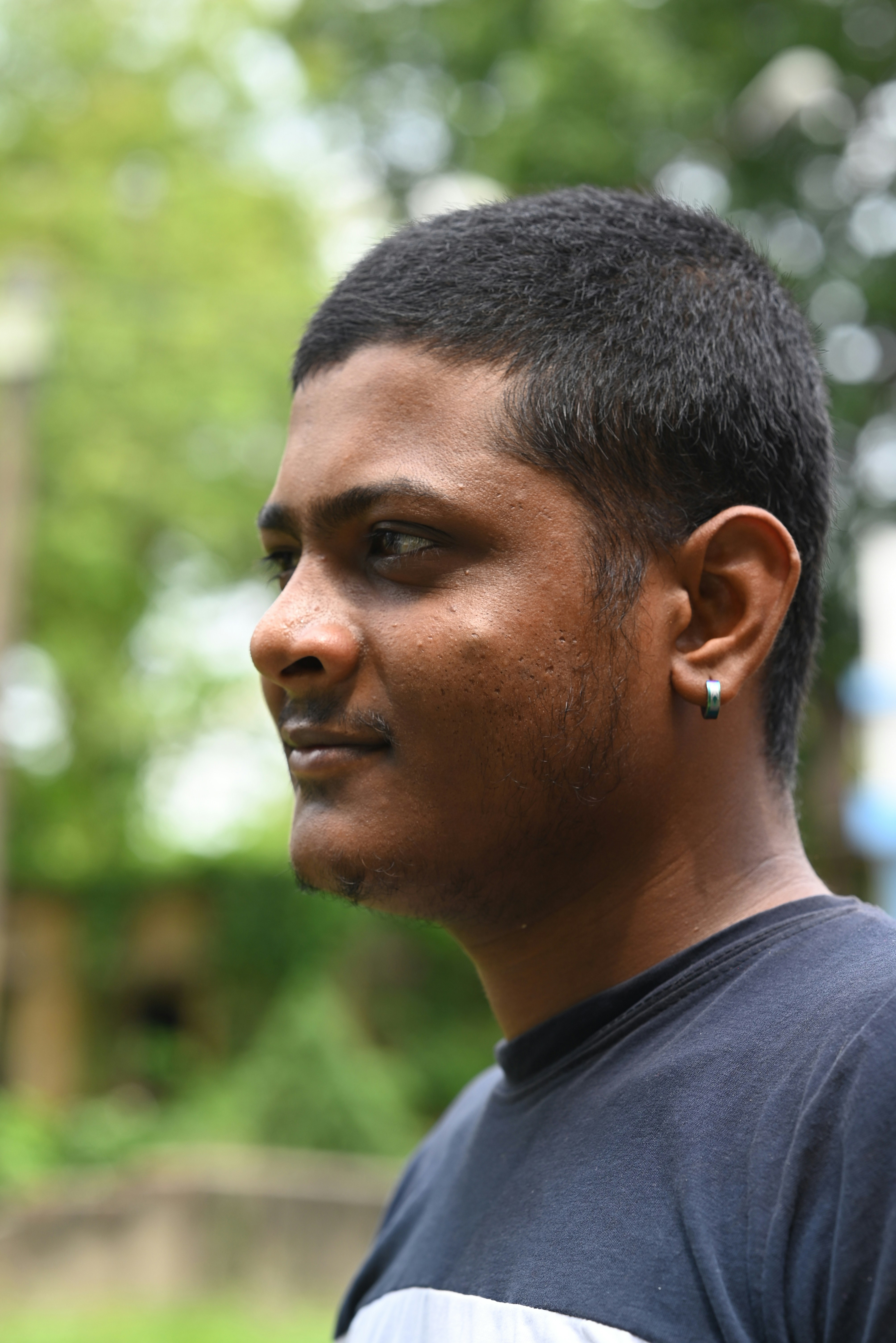 A man smiles, looking to the side.