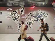 People walk past a glowing world map.