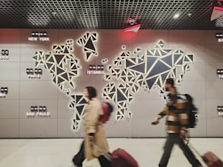 People walk past a glowing world map.