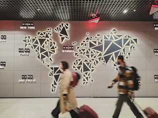 People walk past a glowing world map.