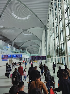 People walk through a modern, spacious airport terminal.
