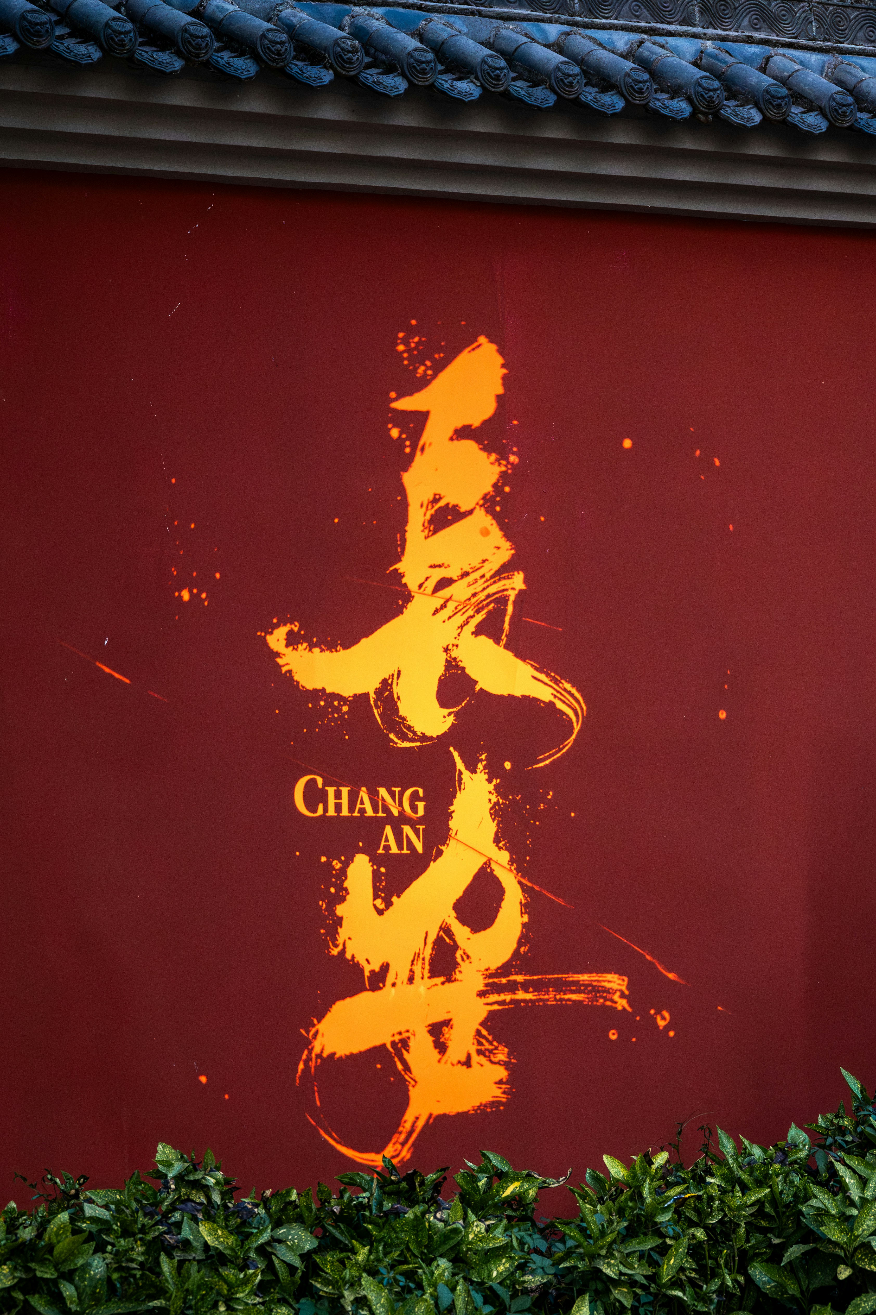 Chinese calligraphy decorates a red wall.