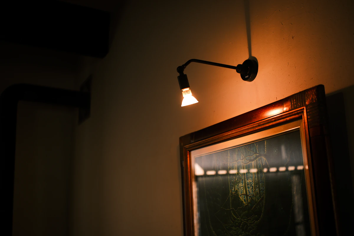 Small mirror bouncing warm lamp light in a cozy lounge