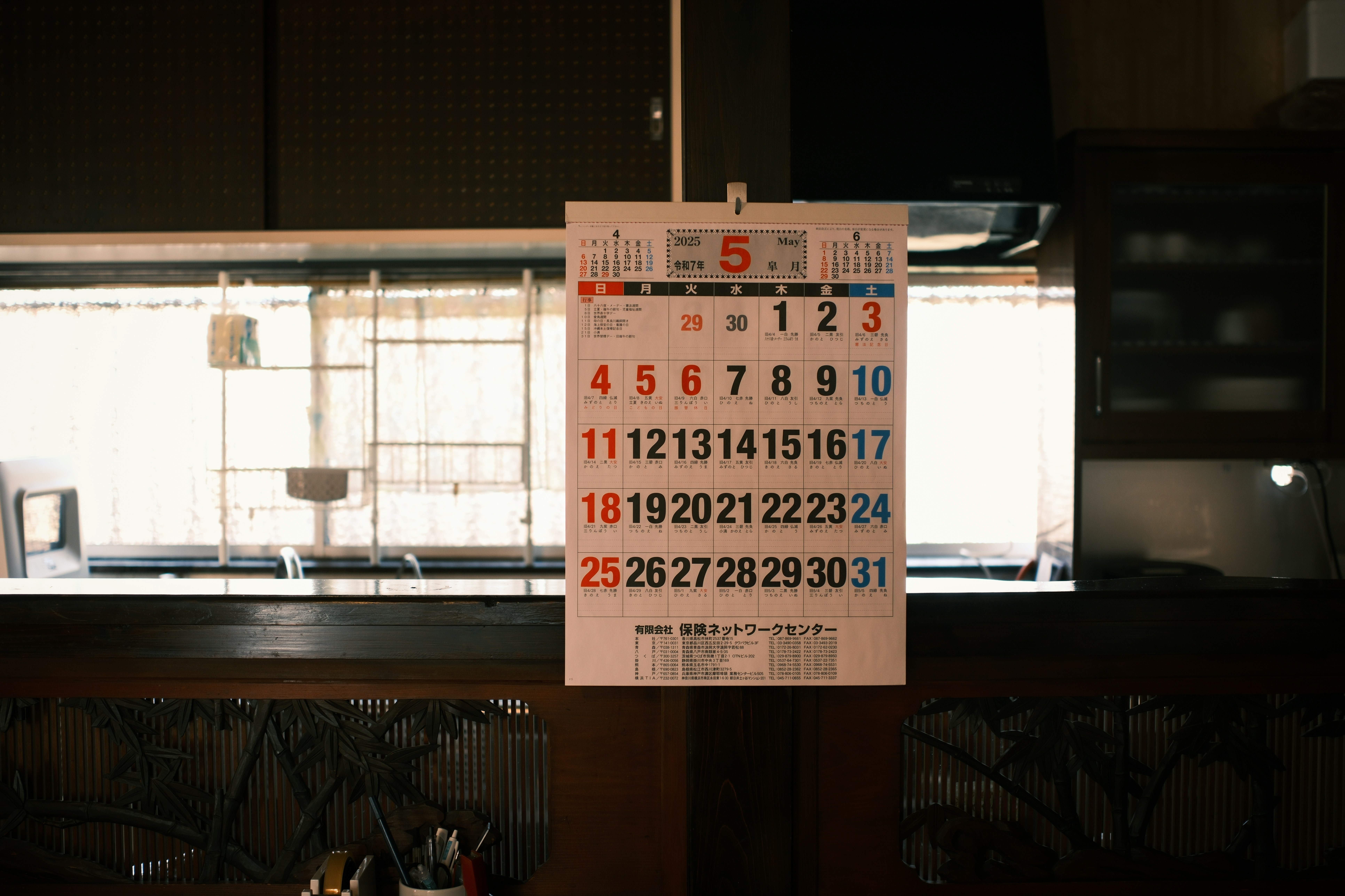 Family kitchen wall with a large calendar surrounded by children's drawings and school letters