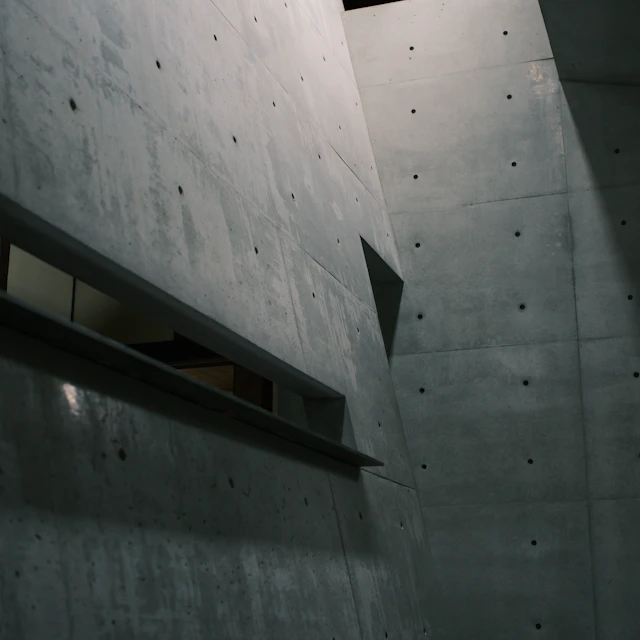A modern interior with smooth bare concrete walls and soft natural light