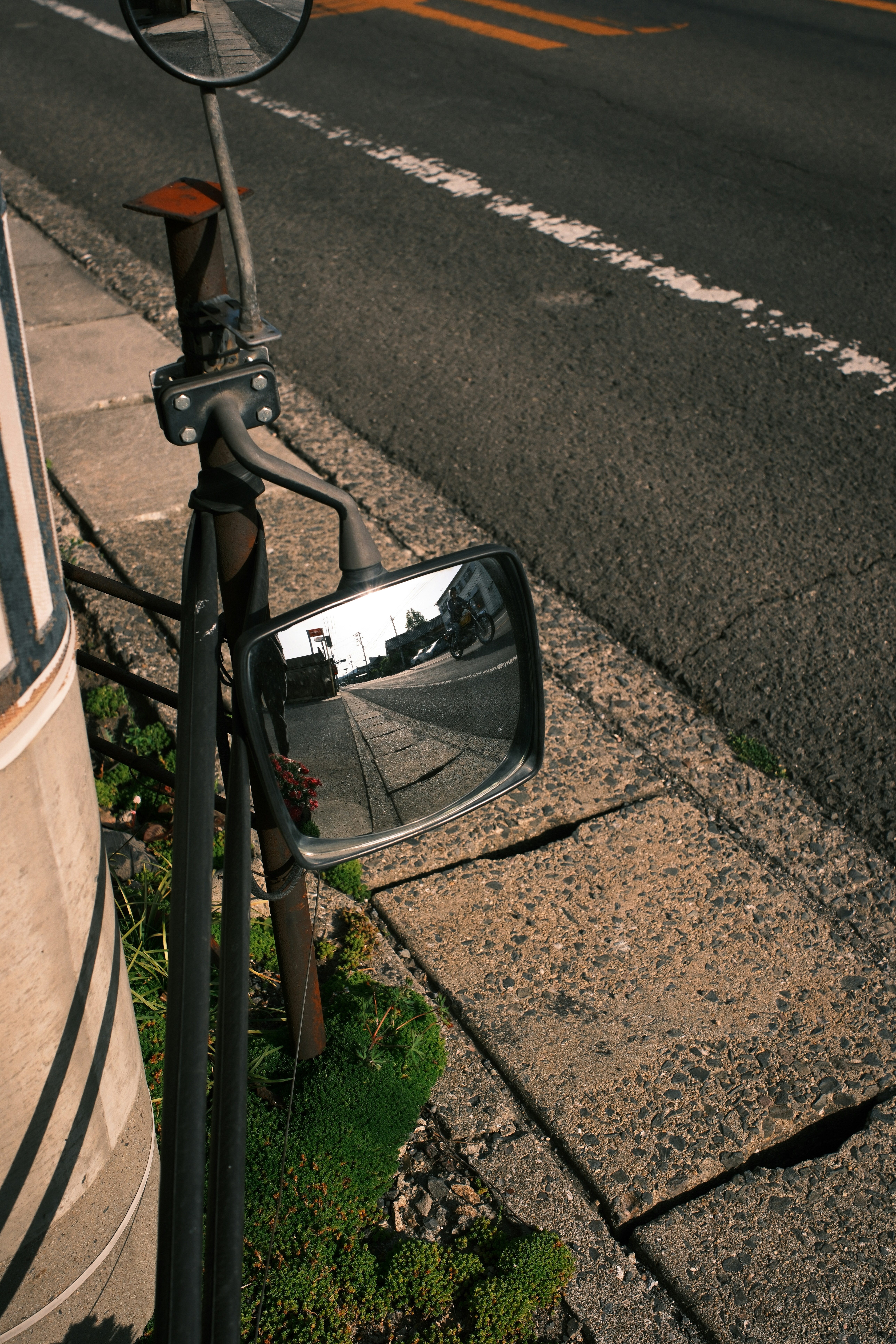 Side mirrors reflect an empty road and sidewalks.