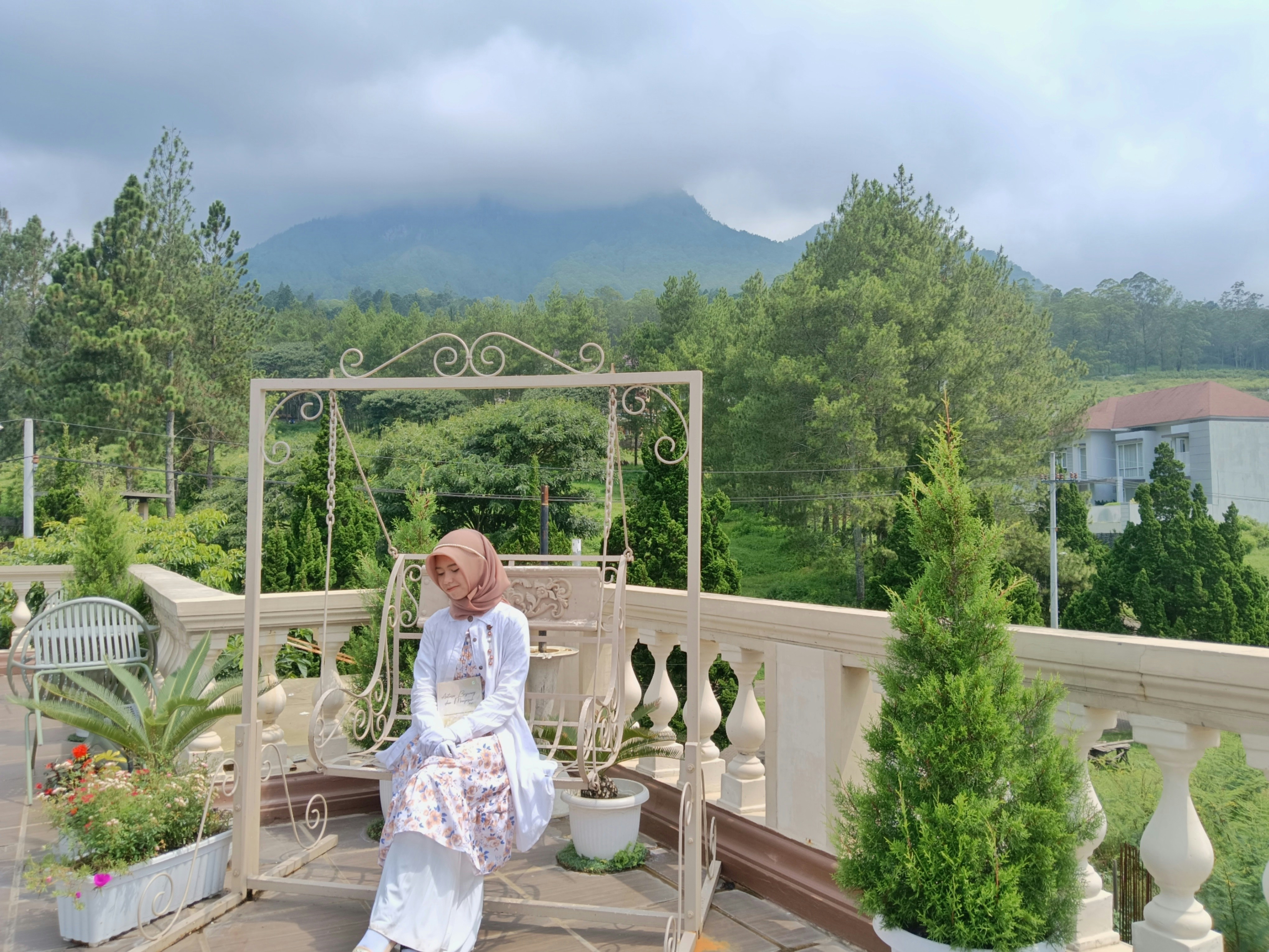 A woman sits in front of a mountain view.