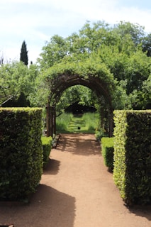 A lush garden path leads through an archway.