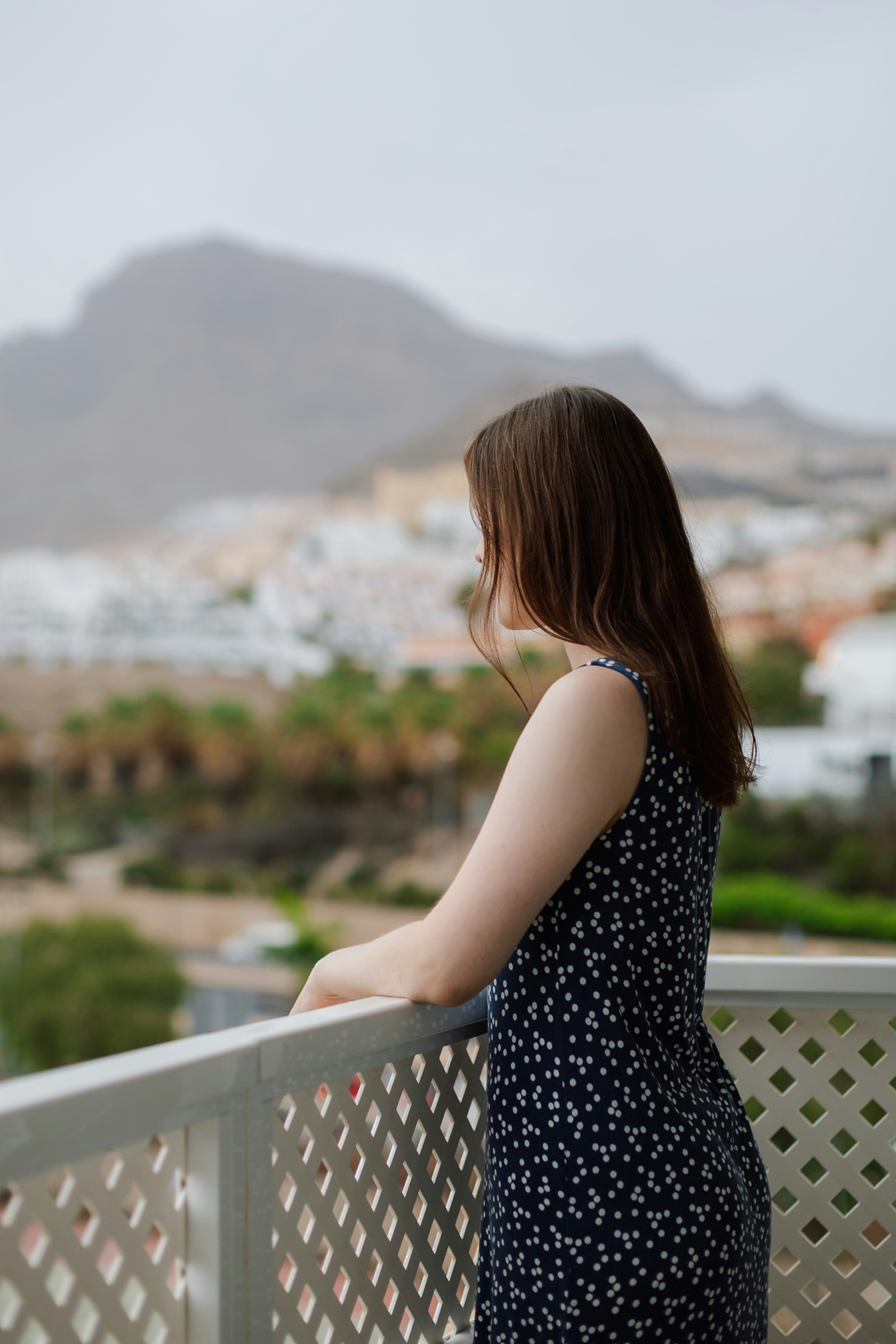 Une femme contemple le paysage depuis le balcon.