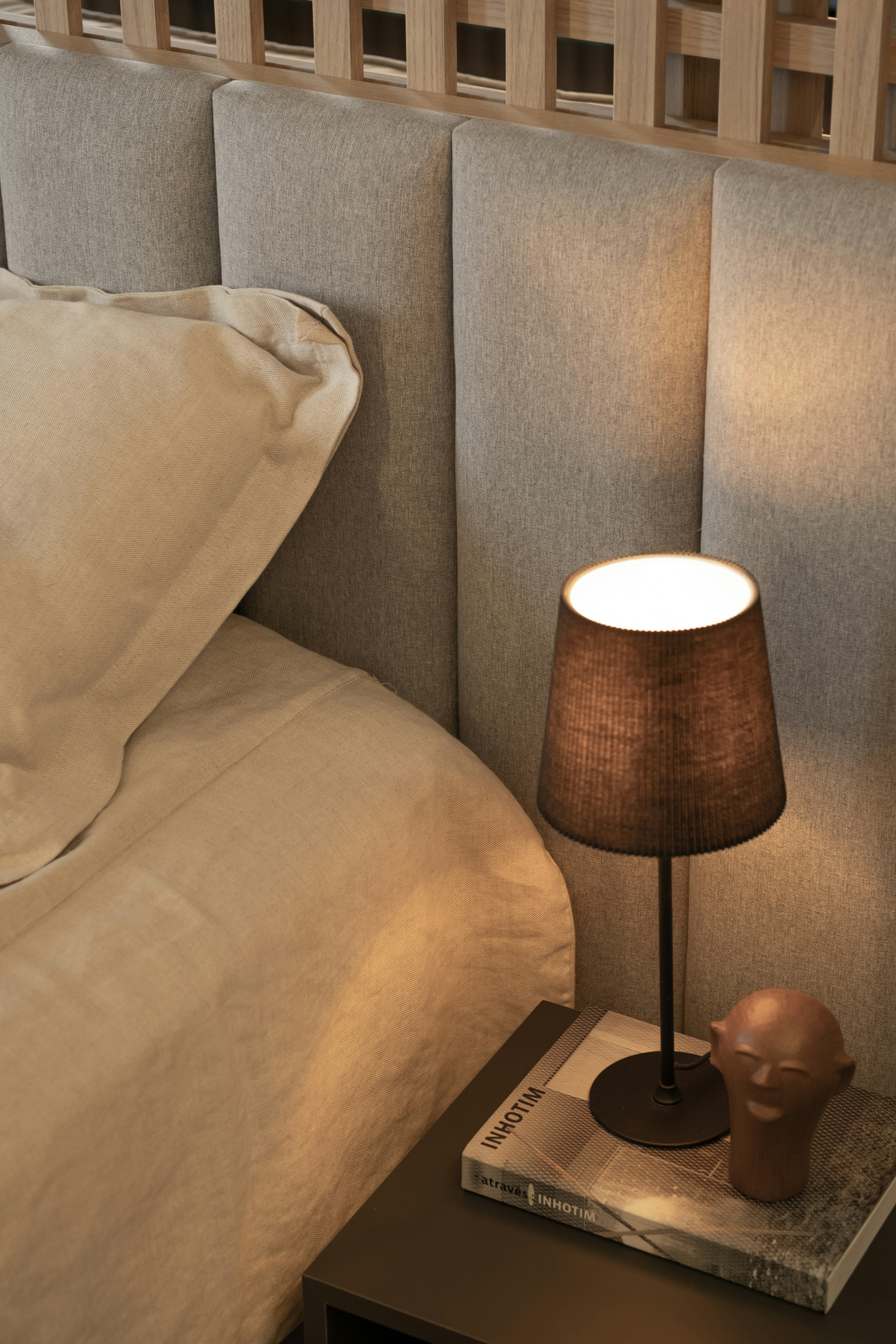 Cozy bedroom scene featuring a lamp and a book.
