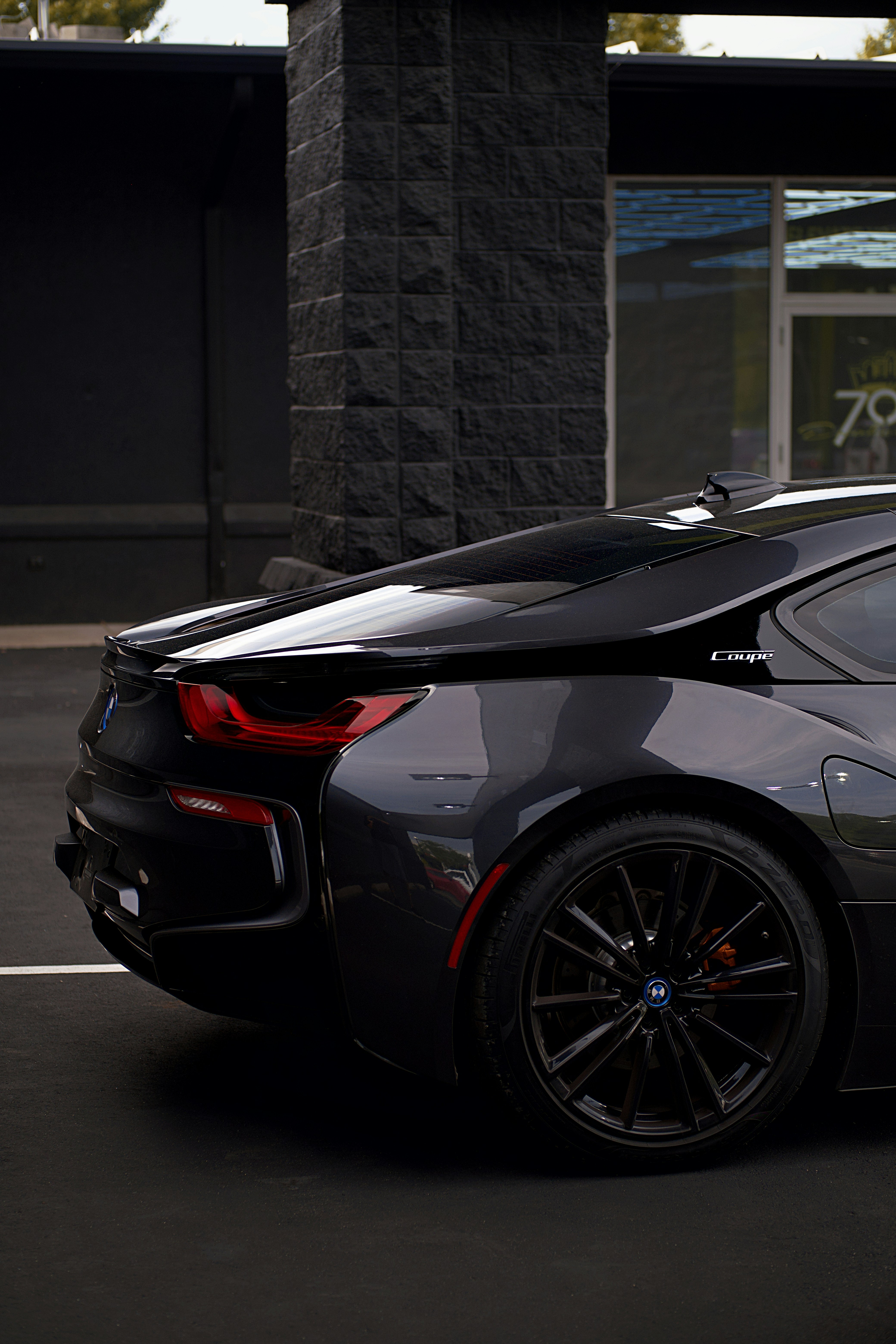 Un'elegante auto nera è parcheggiata vicino a un edificio.