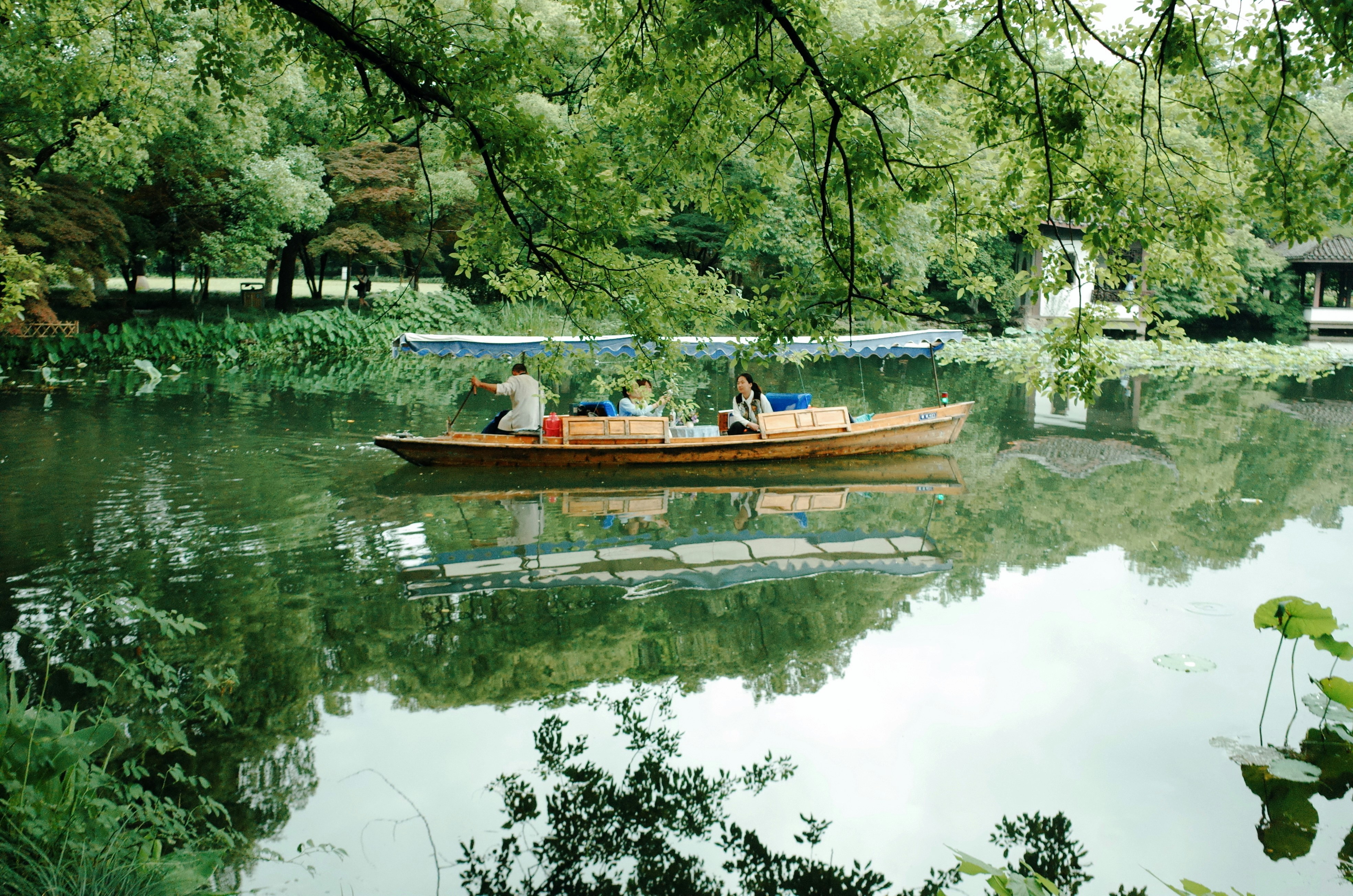 People ride a boat on a tranquil lake.