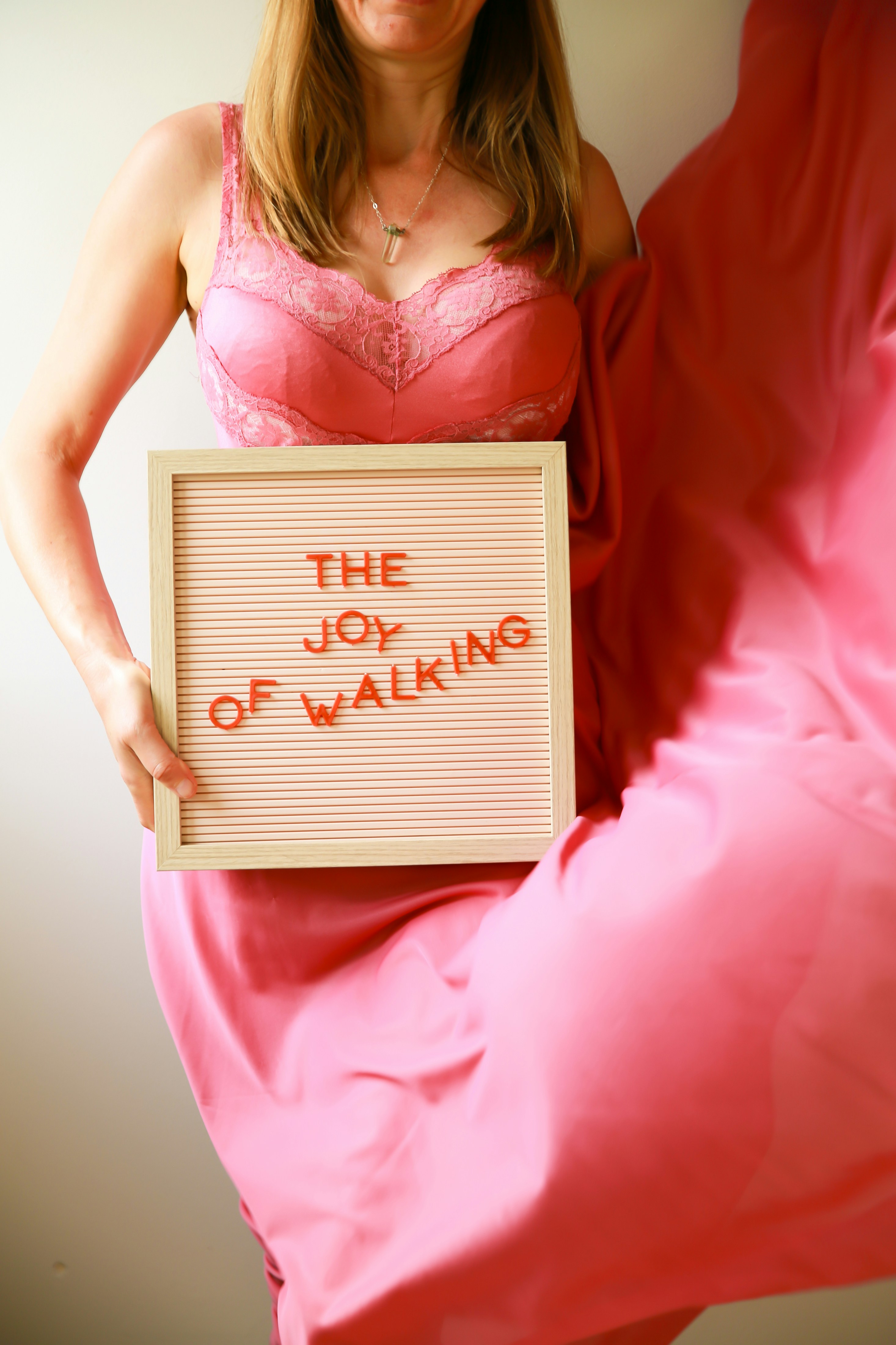 Eine Frau hält ein Schild mit der Aufschrift "Die Freude am Gehen".