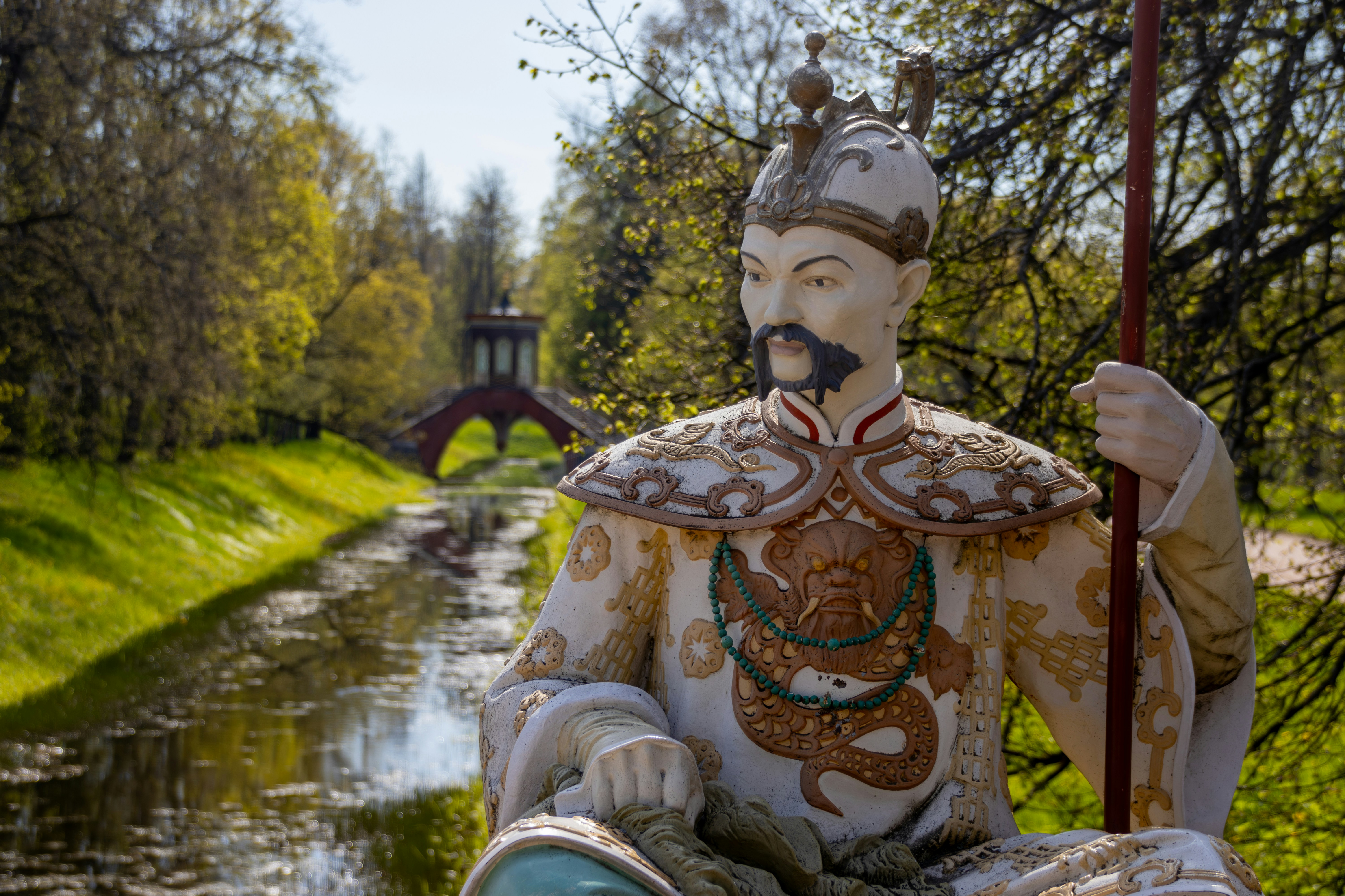 Statue of a chinese warrior in a garden.