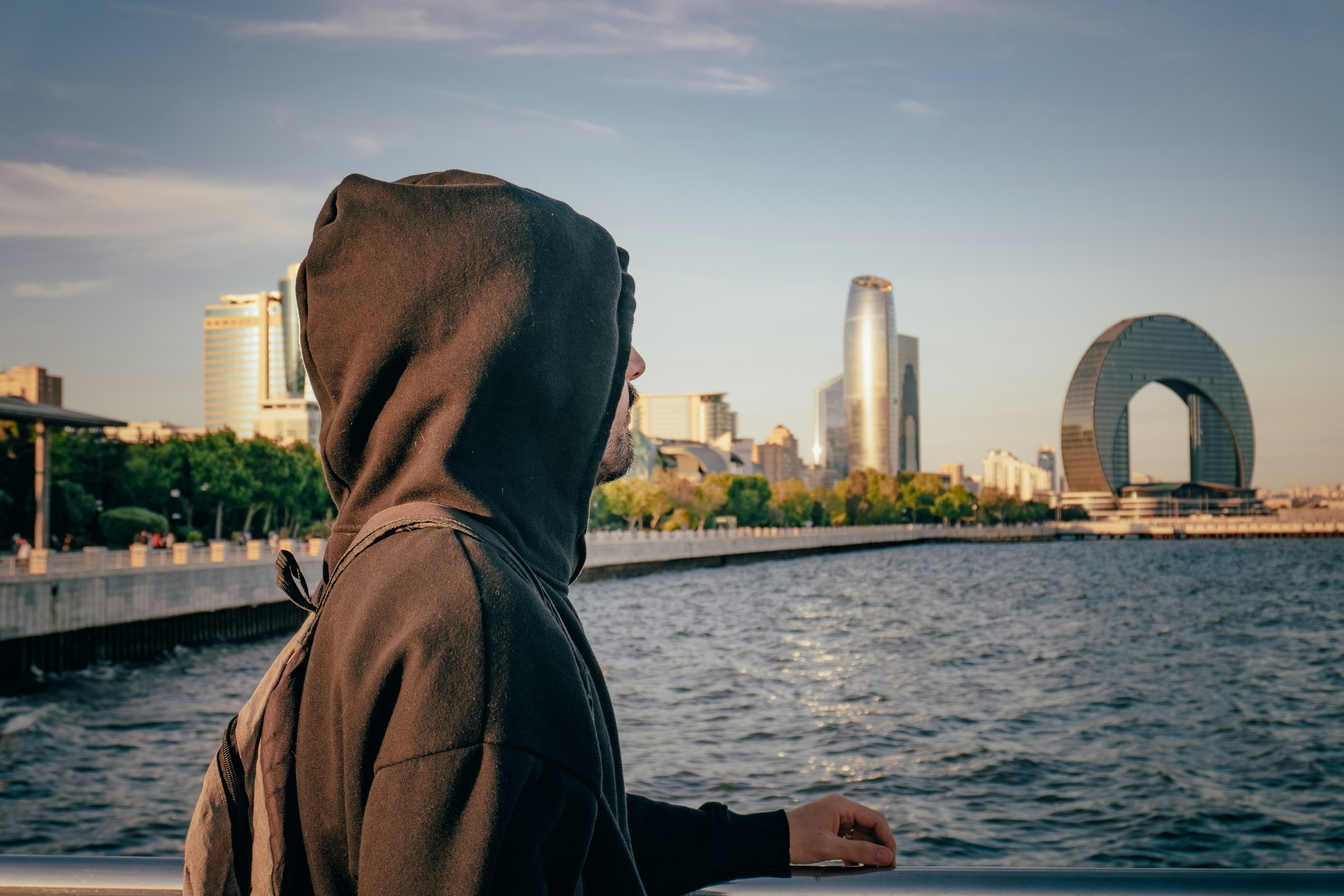 Person in hoodie looks at a city skyline