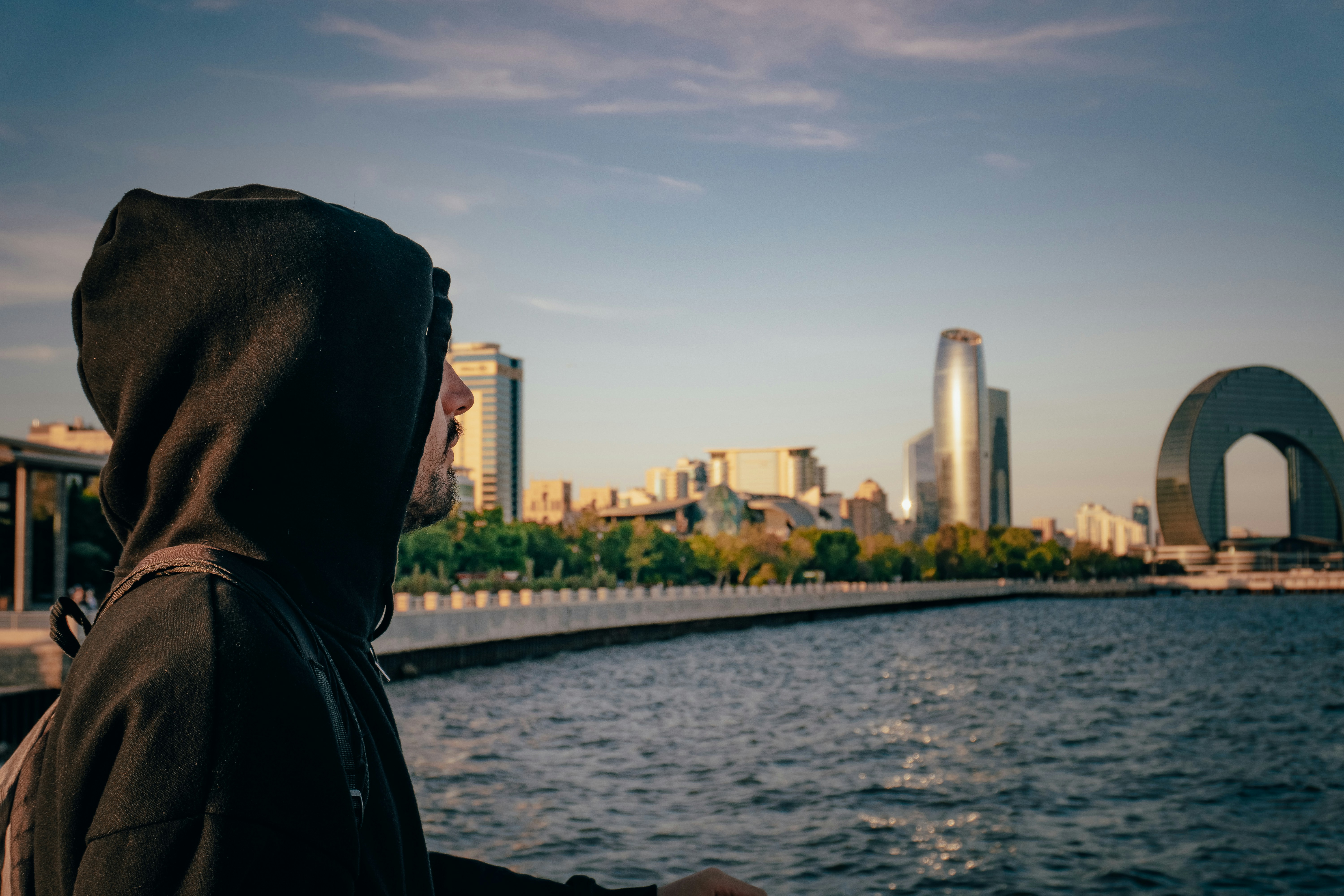 Man gazes at a city skyline from the waterfront