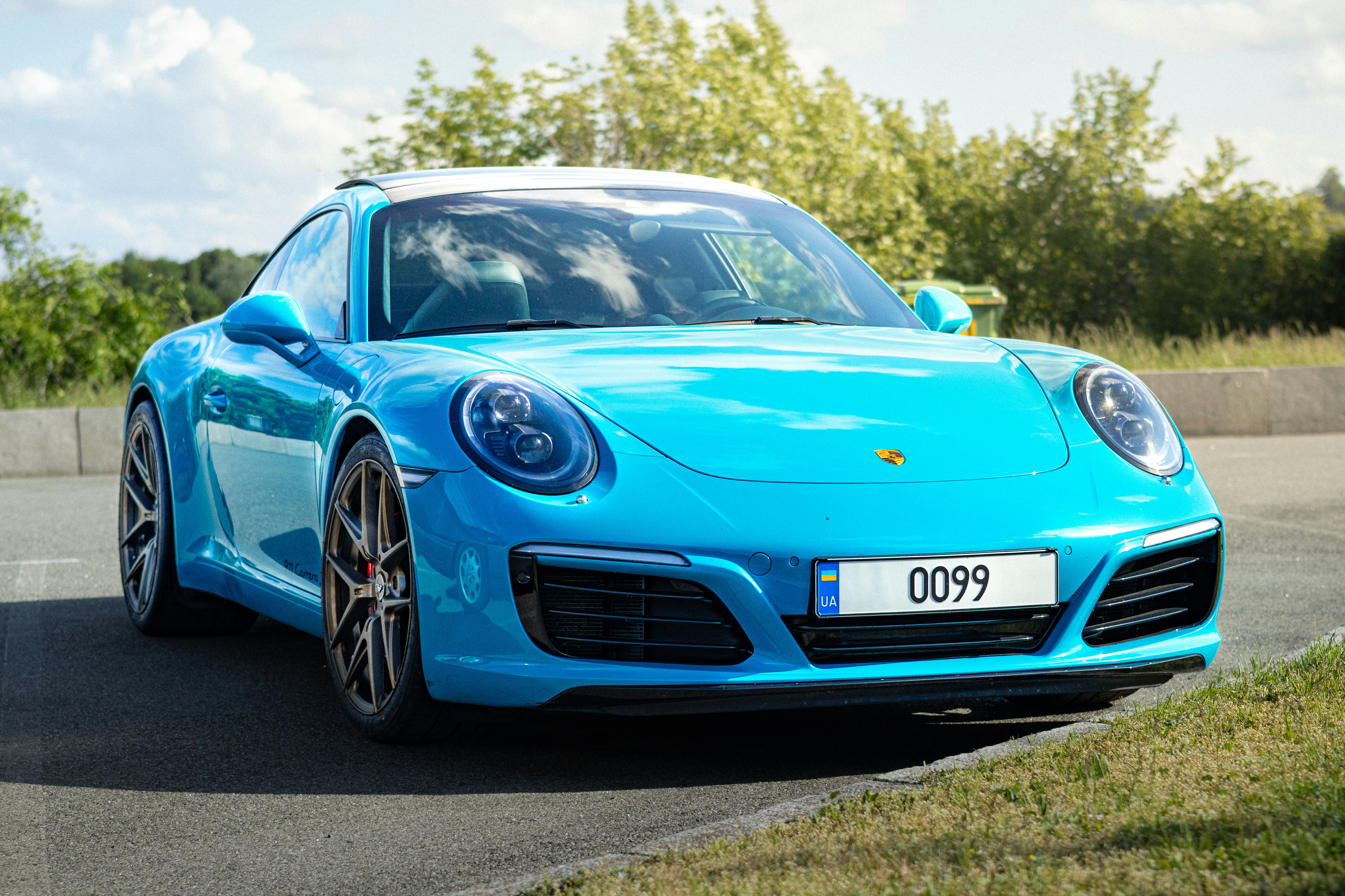 Here is a caption for the image: a stunning, blue porsche car.