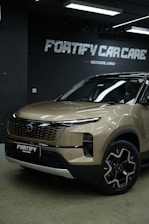 A brown car is parked in front of car care.