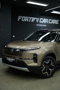 A brown car is parked in front of car care.